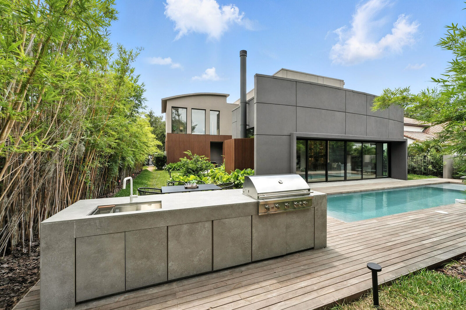Backyard with outdoor kitchen and pool — after re-facing