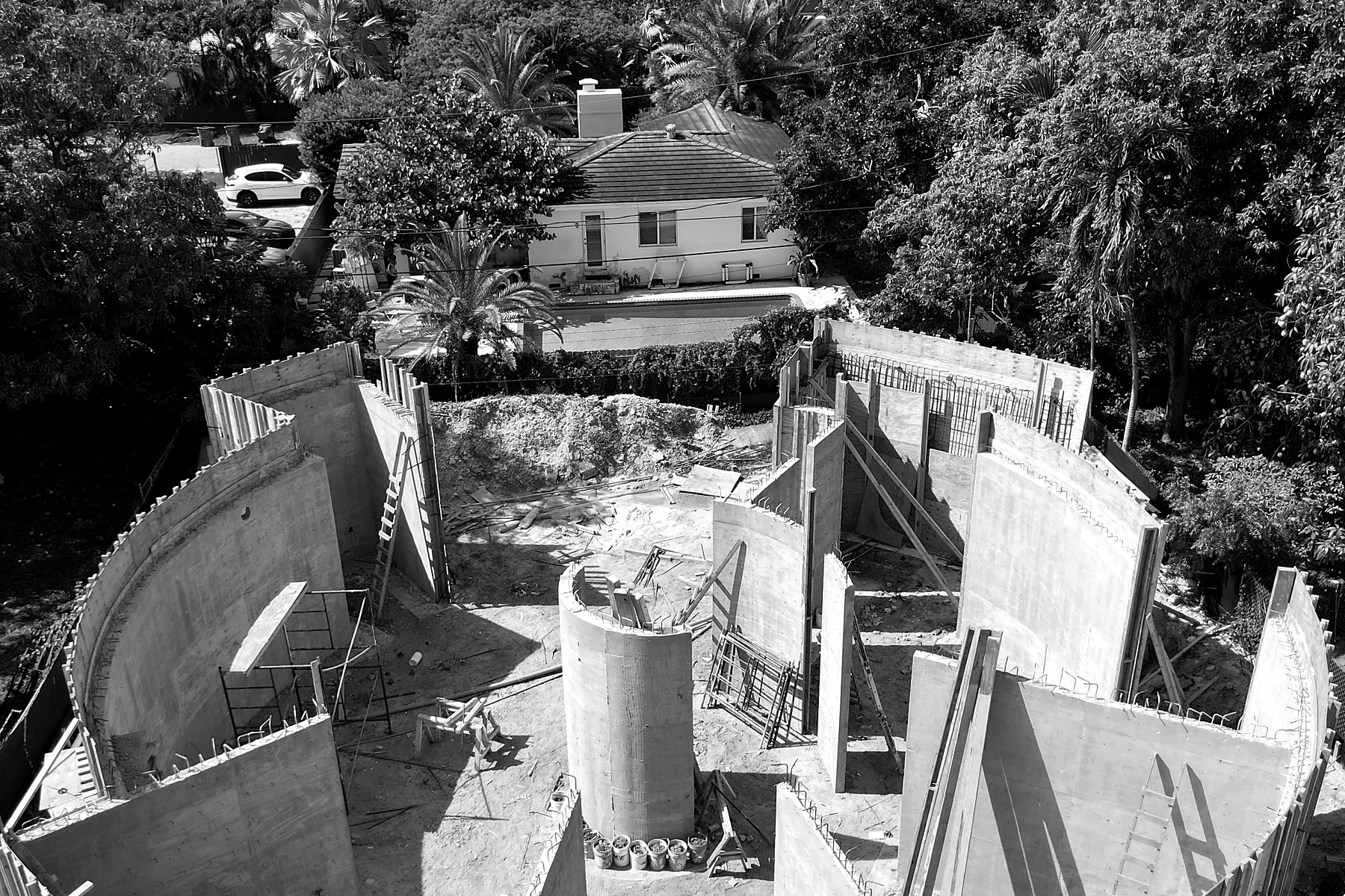 211 — concrete walls rising with the neighborhood beyond, June 2026
