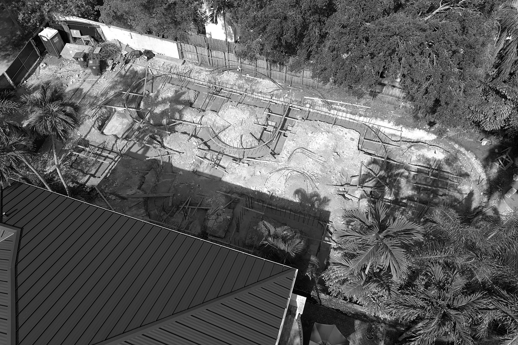Española — the curved plan emerging among the palms, aerial, July 2026